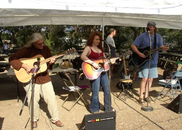 Lindsey Eck plays acoustically under a canopy with friends